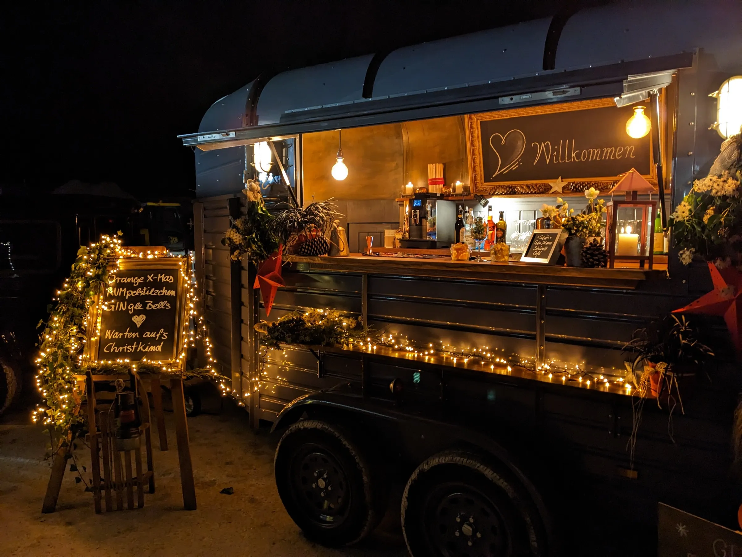 Der weihnachtlich dekorierte Wagen mit Lichterkette und Getränkekarte am Abend