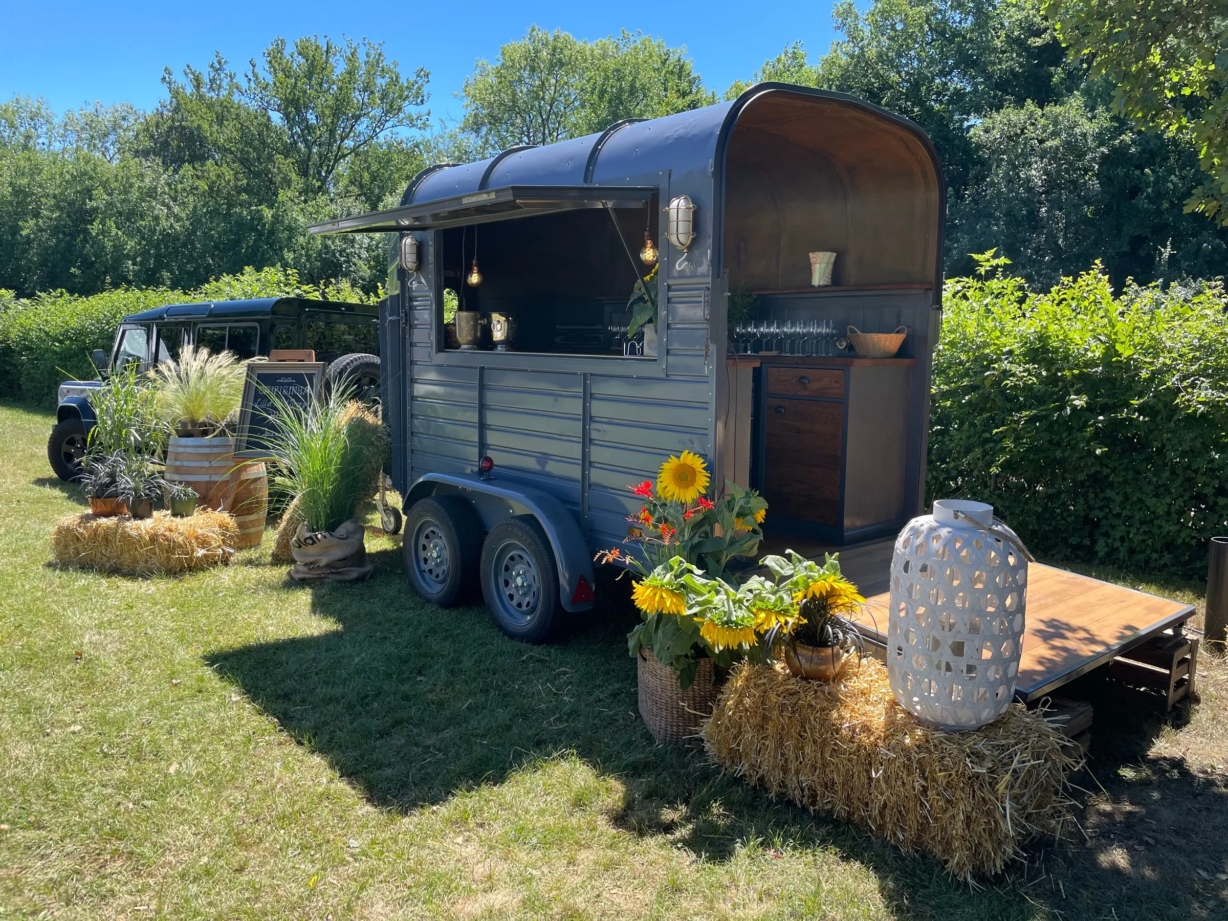 Der Wagen mit geöffneter Klappe im Garten, Sonnentag